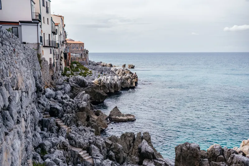 Clear turquoise sea along the rocky Cefalù coast where boat tours snorkel