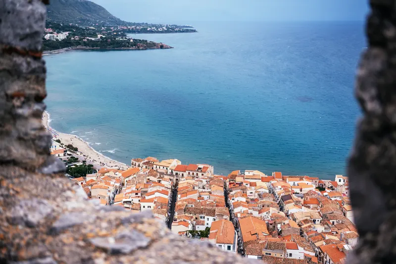 Aerial view of Cefalù's terracotta rooftops and the sea from La Rocca