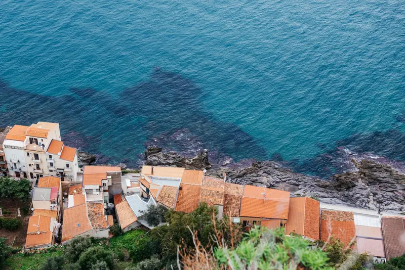 Cefalù's old-town rooftops meeting the clear turquoise sea